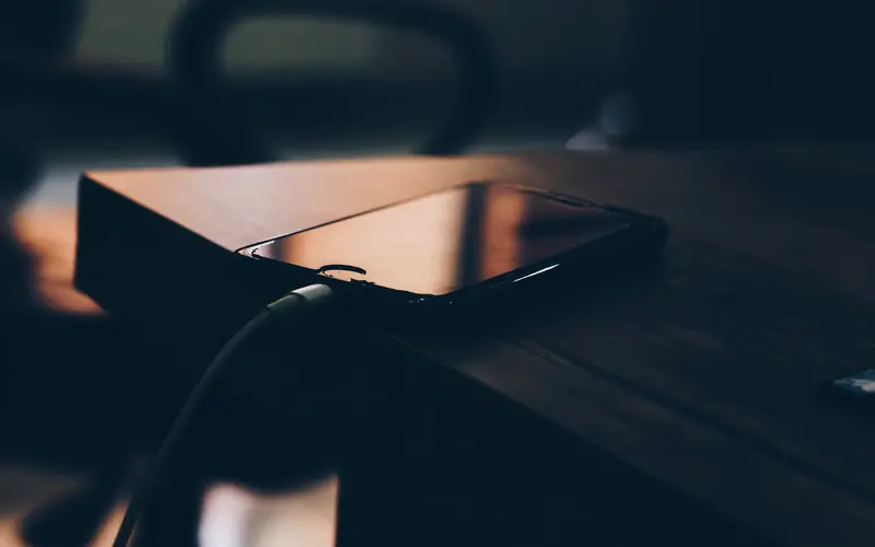 Smartphone posé sur un bureau sombre