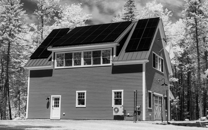 Maison individuelle équipée de panneaux solaires, en noir et blanc