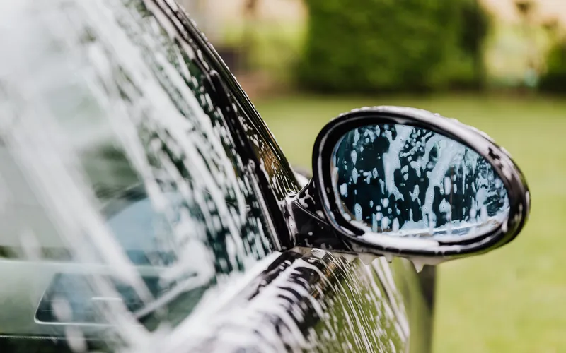 Rétroviseur de voiture couvert de mousse de lavage