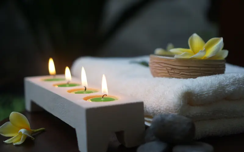 Bougies, serviette et fleurs de frangipanier dans un spa